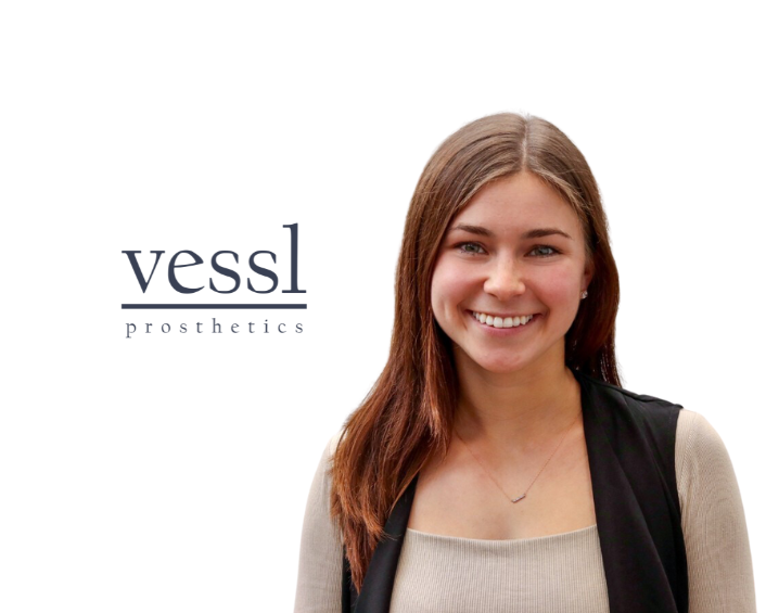 A woman smiling in a nude tshirt and a black cardigan on the left-hand side and Vessl Prosthetics logo on the right hand side