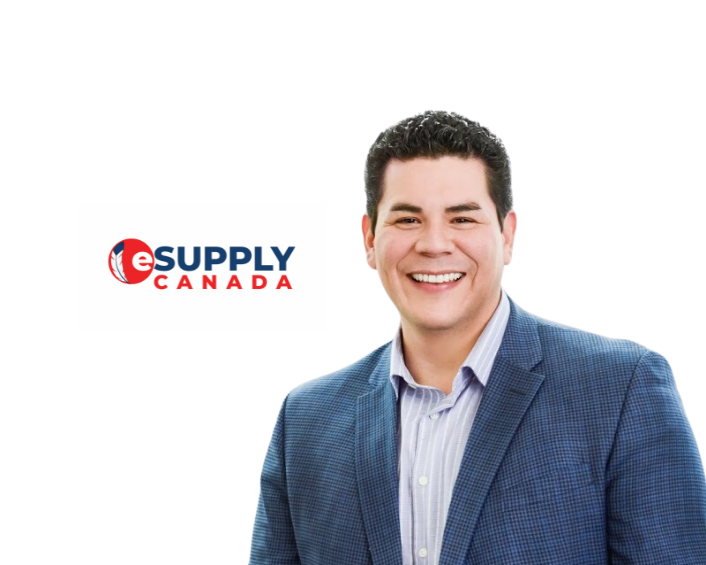 A man in a blue shirt and deep navy blazer smiling against a white background on the left hand side. The right hand side of the image has eSupply logo