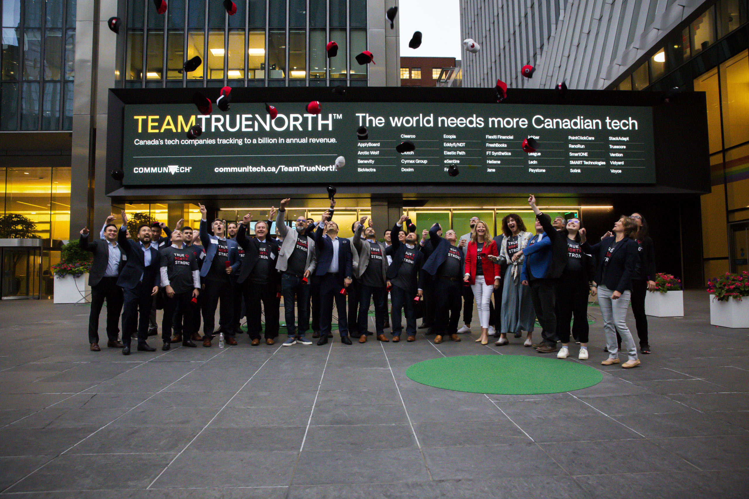 Paystone employees standing in front of Team True North celebrating.